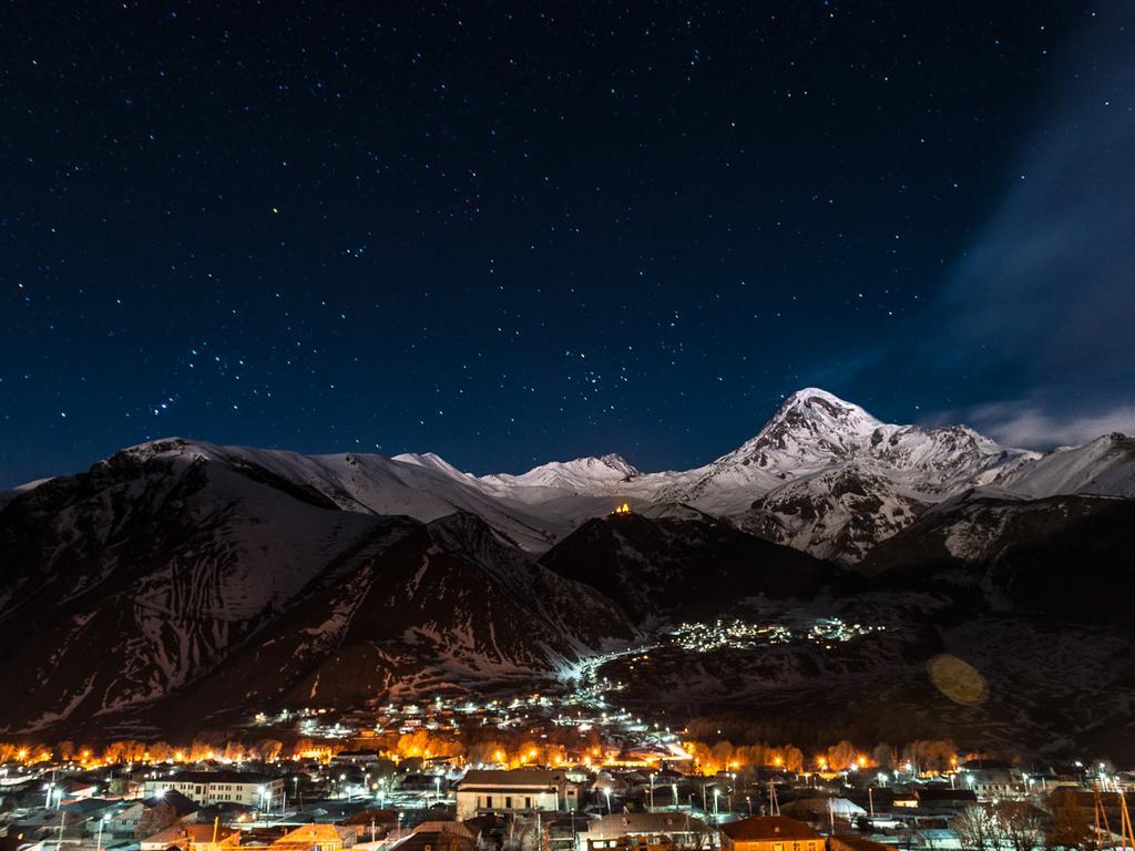 Rooms Hotel Kazbegi Exterior photo Night view of the town